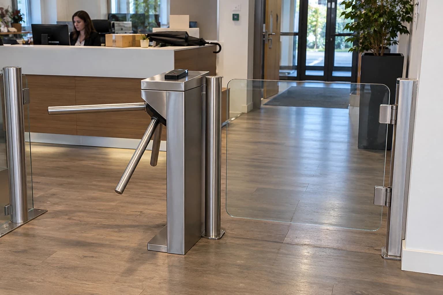 Tourniquet à trois bras et portillon vitré séparé devant un accueil de bureaux