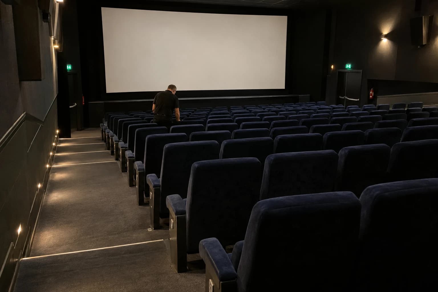 Illustration d’un cinéma fictif entre deux séances, avec un salarié dans les rangées et une circulation dégagée