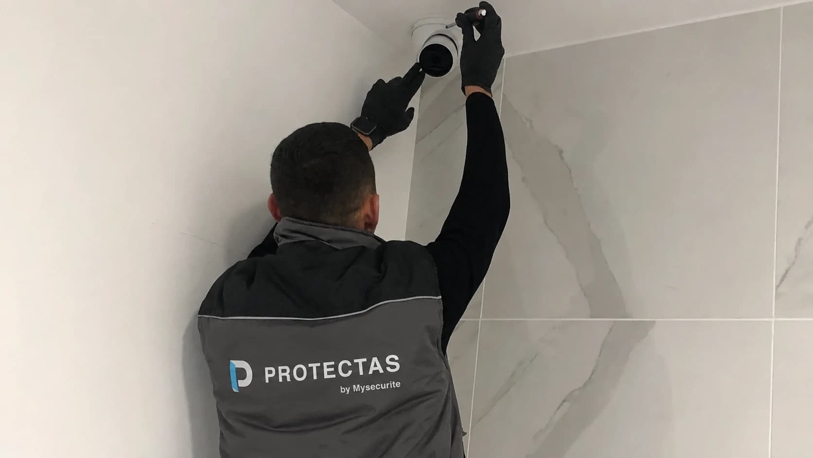 Technicien installant une caméra de vidéosurveillance